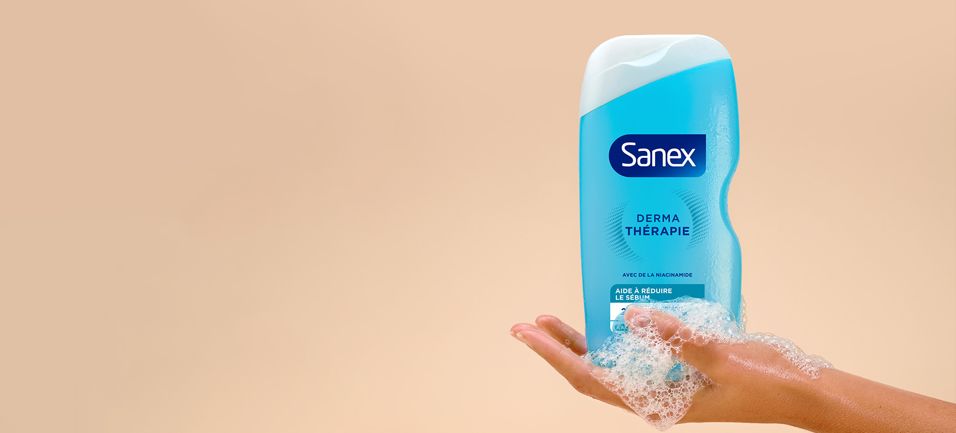 une main de femme avec un peu de mousse tenant le produit Sanex Derma thérapie peaux grasses