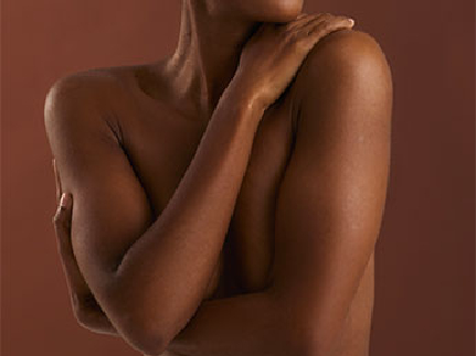 Plan moyen du torse et des bras d'une femme noire se serrant contre elle-même.