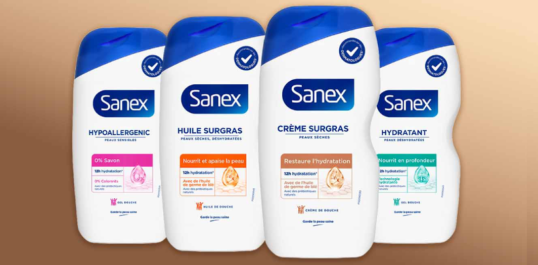Quatre flacons de la gamme Sanex Derma Care body wash alignés. Les variantes incluent, Hypoallergénique, Creme Surgras, Huile Surgras et Hydratant.